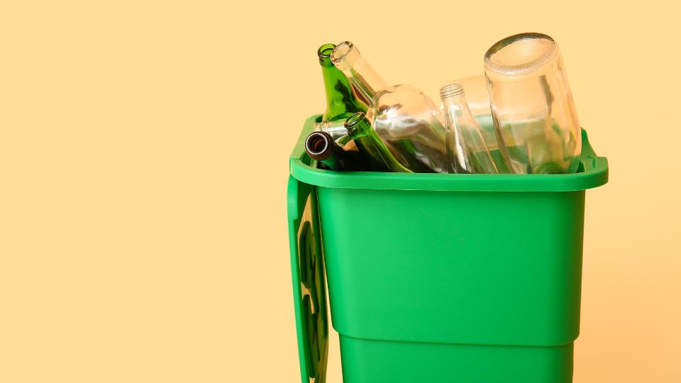 Glass waste in a green bin.