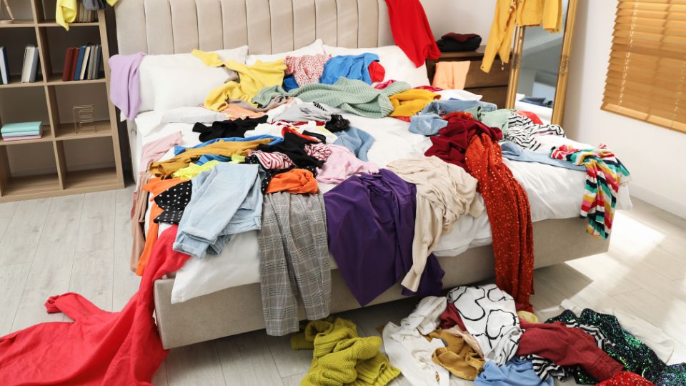 lots of clothes spread across a bed