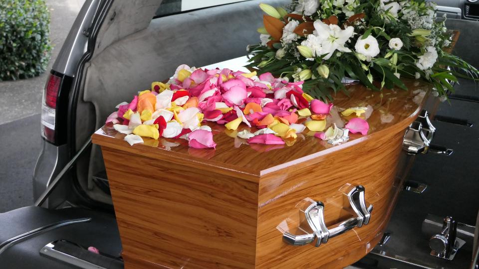 flowers on top of a coffin at a funeral