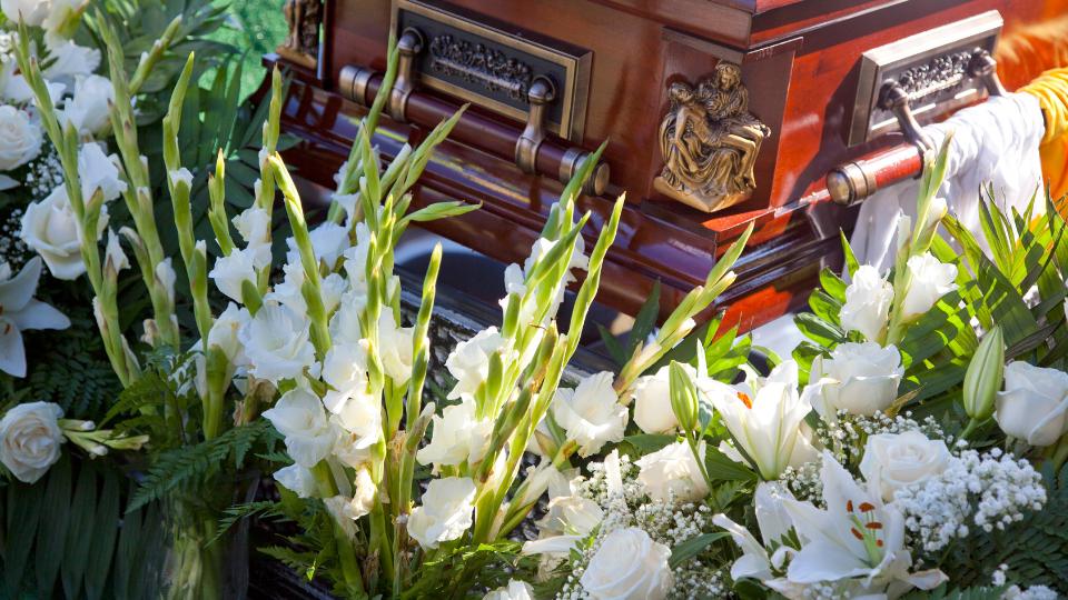 flowers surrounding a coffin during a funeral