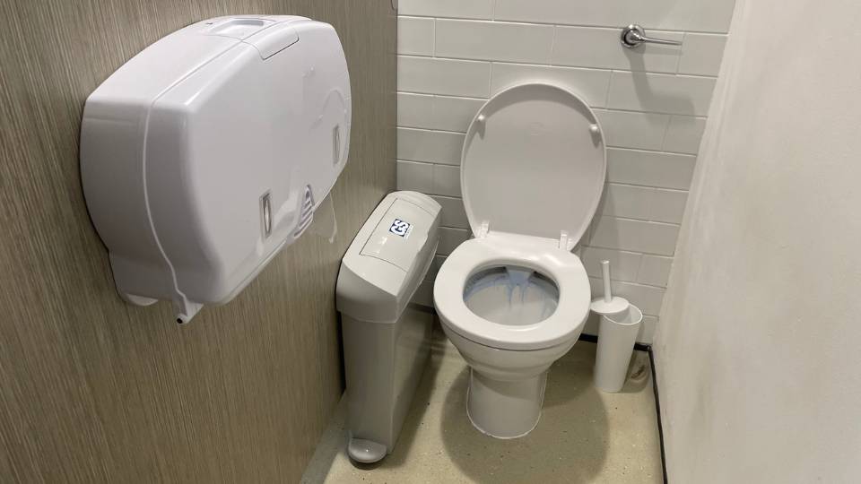 a sanitary waste bin in a toilet cubicle