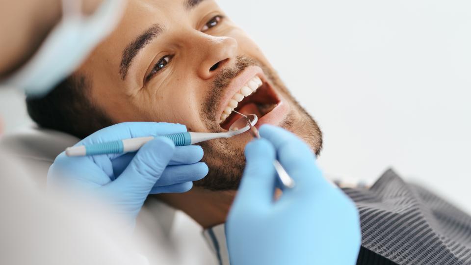 dentist examining someones mouth and using amalgam for teeth