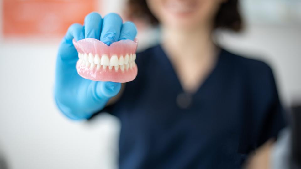 dentist holding an amalgam mold of teeth