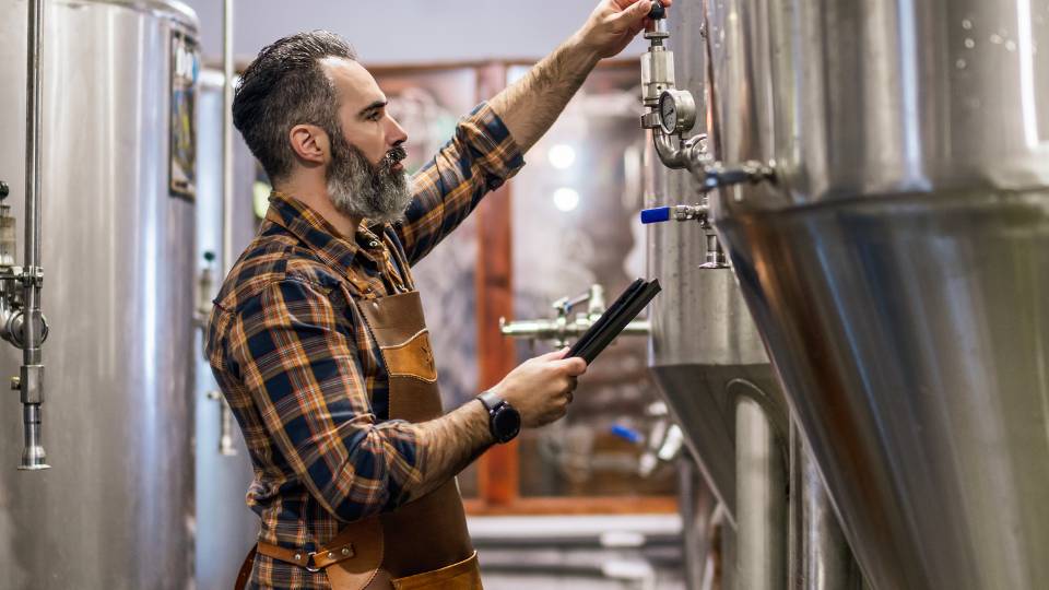 a brewer working in a brewery checking waste
