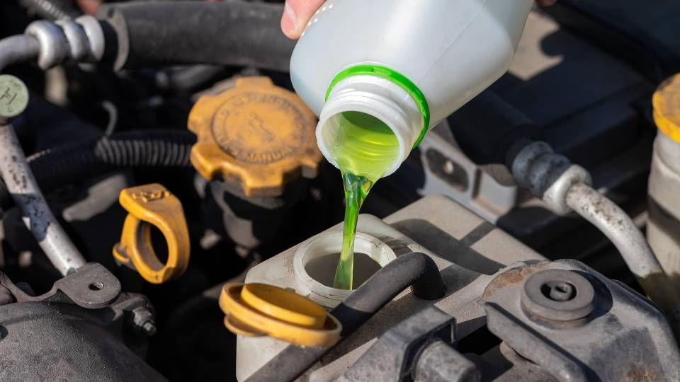 a green chemical going into a car engine 