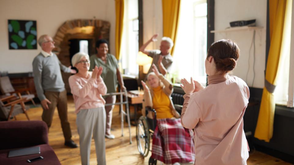 elderly people in care home dancing with nurse