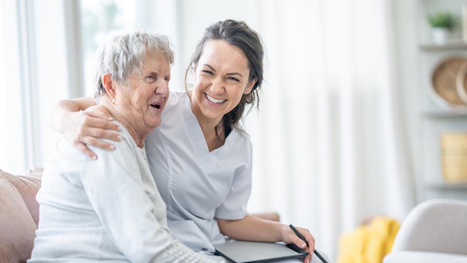 an elderly person in a care home with a nurse supporting them