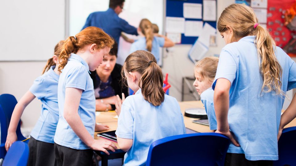 children in a primary school working with paper and pens