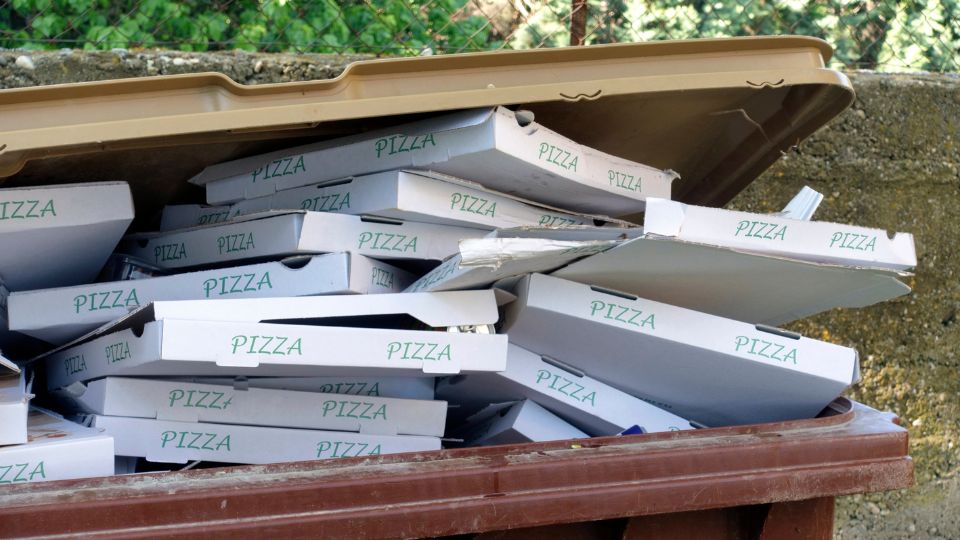 Pizza boxes over filling a bin.