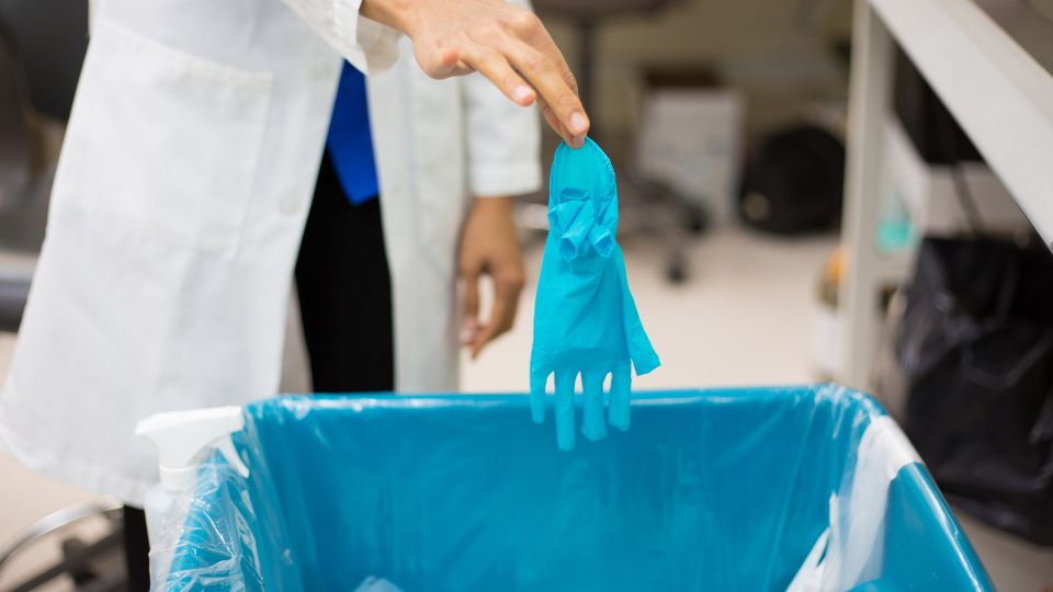 Blue glove being disposed of in a laboratory. 