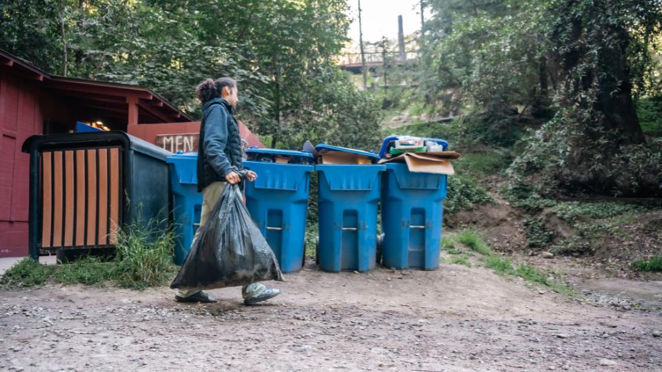Man using the recycling bins at a campsite