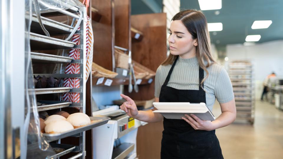 Woman taking inventory stock check in a bakery
