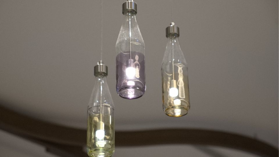 Glass bottle lamps hanging from ceiling by string.