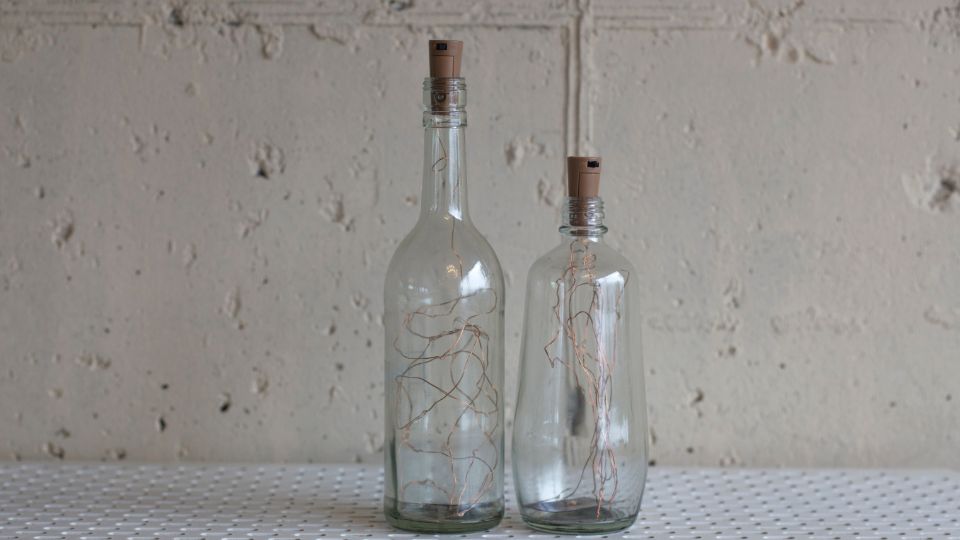 Two glass bottles with fairy lights inside. 