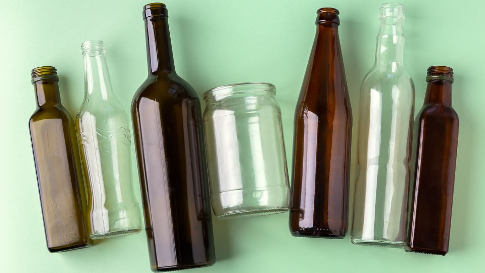 Glass bottles and jar lay out on a table.
