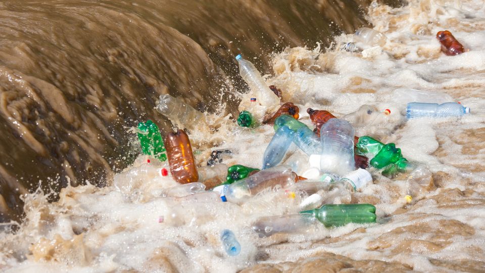 Plastic bottles at the end of a waterfall leading to marine pollution.