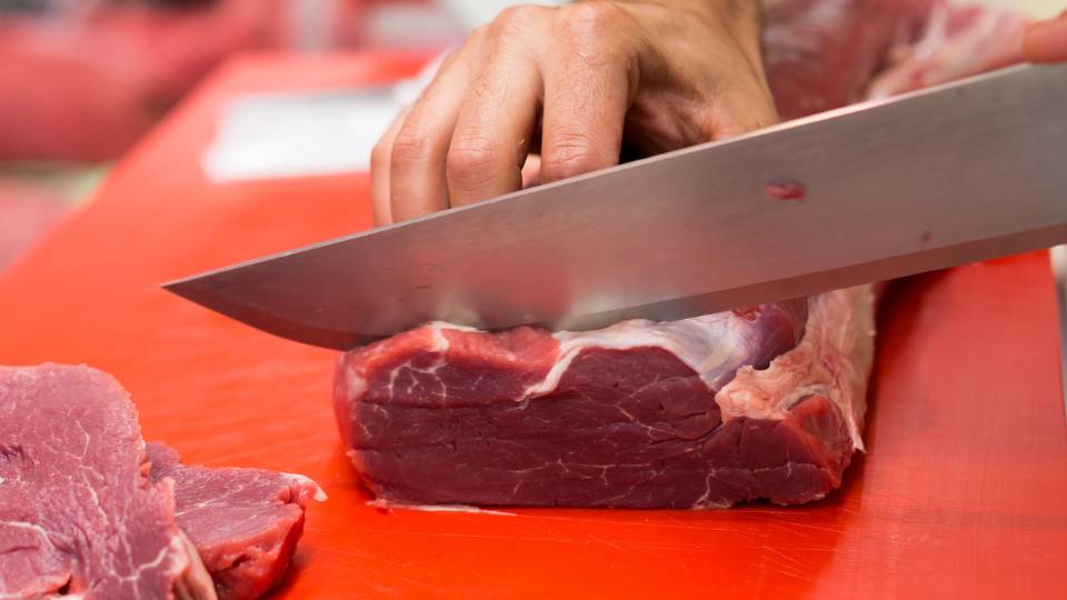 meat being chopped by a butcher