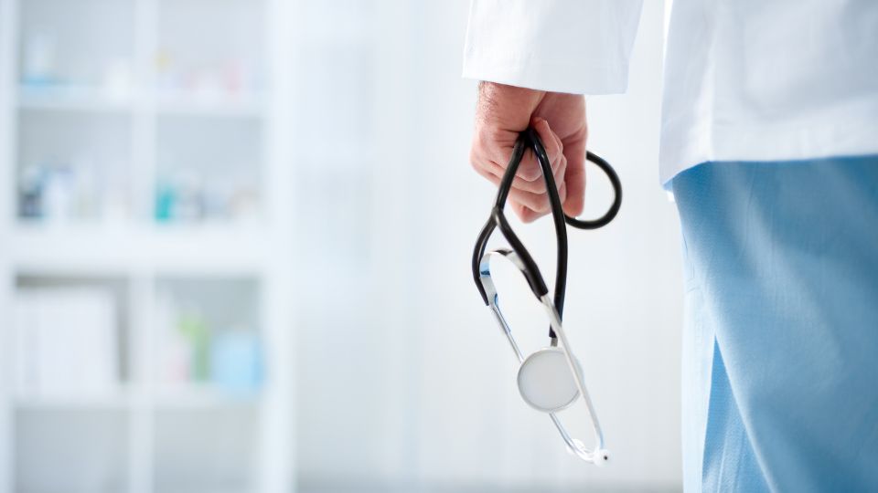 a doctor holding a stethoscope in a hospital 