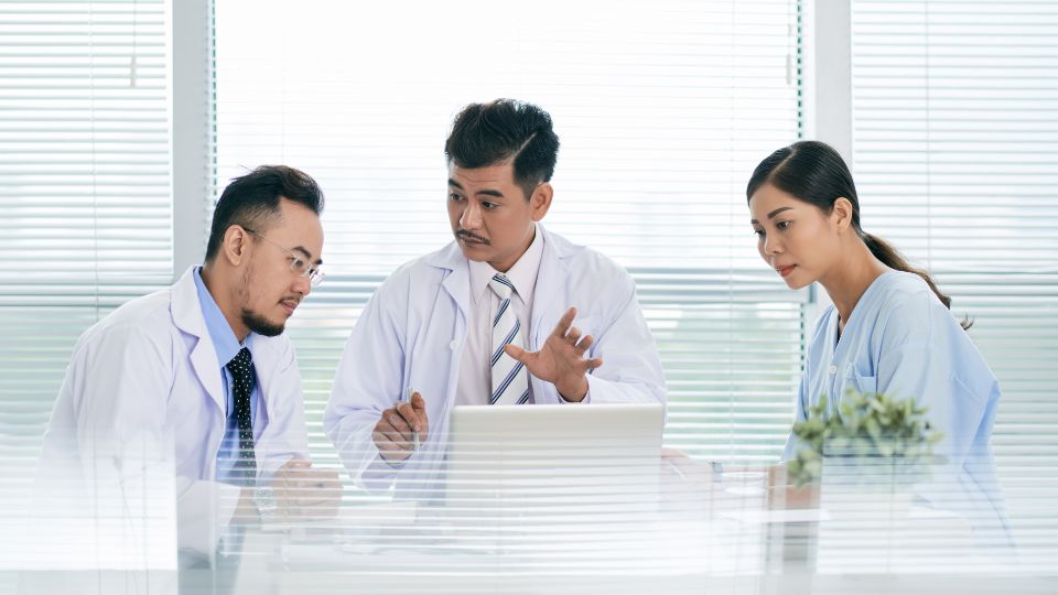 three hospital employees discussing waste innovation