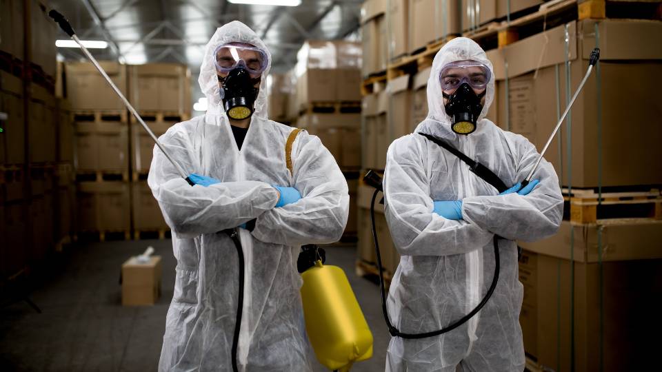 two pest control workers in PPE dealing with infestation