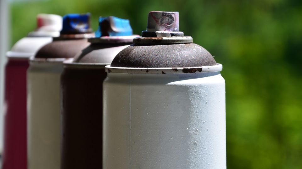 Aerosol cans lined up next to each other.