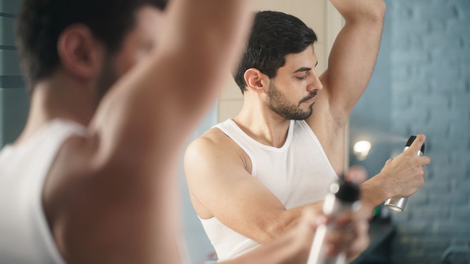 Guy spraying aerosol deodorant can.