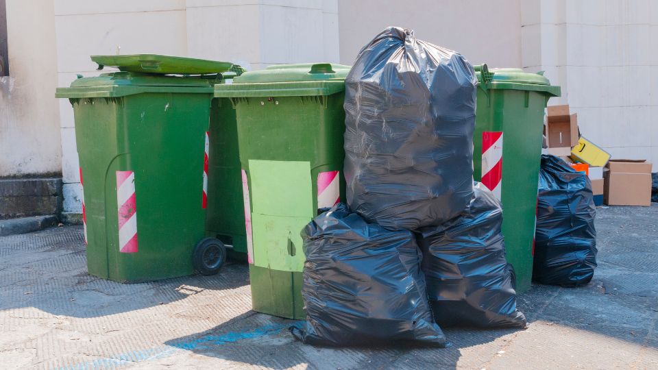 Overfilled green wheelie bins