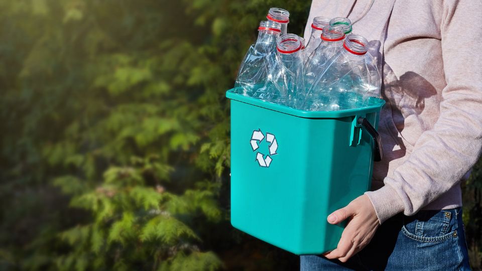 Recycling bin filled with clear plastic bottles.